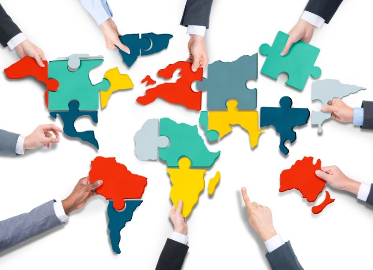 Diverse Business People's Hands with Cartography Puzzle